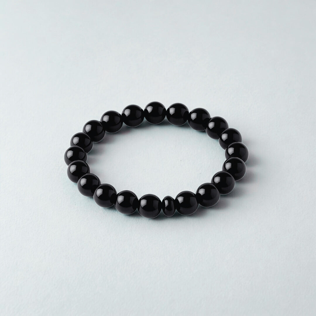 Black beaded bracelet on a light gray background
