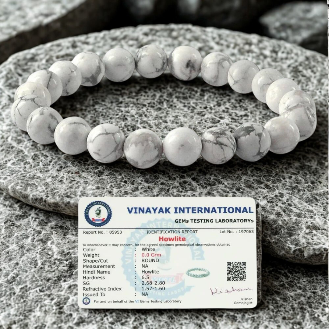 White howlite bracelet on a stone surface with a Vinayak International certification label.