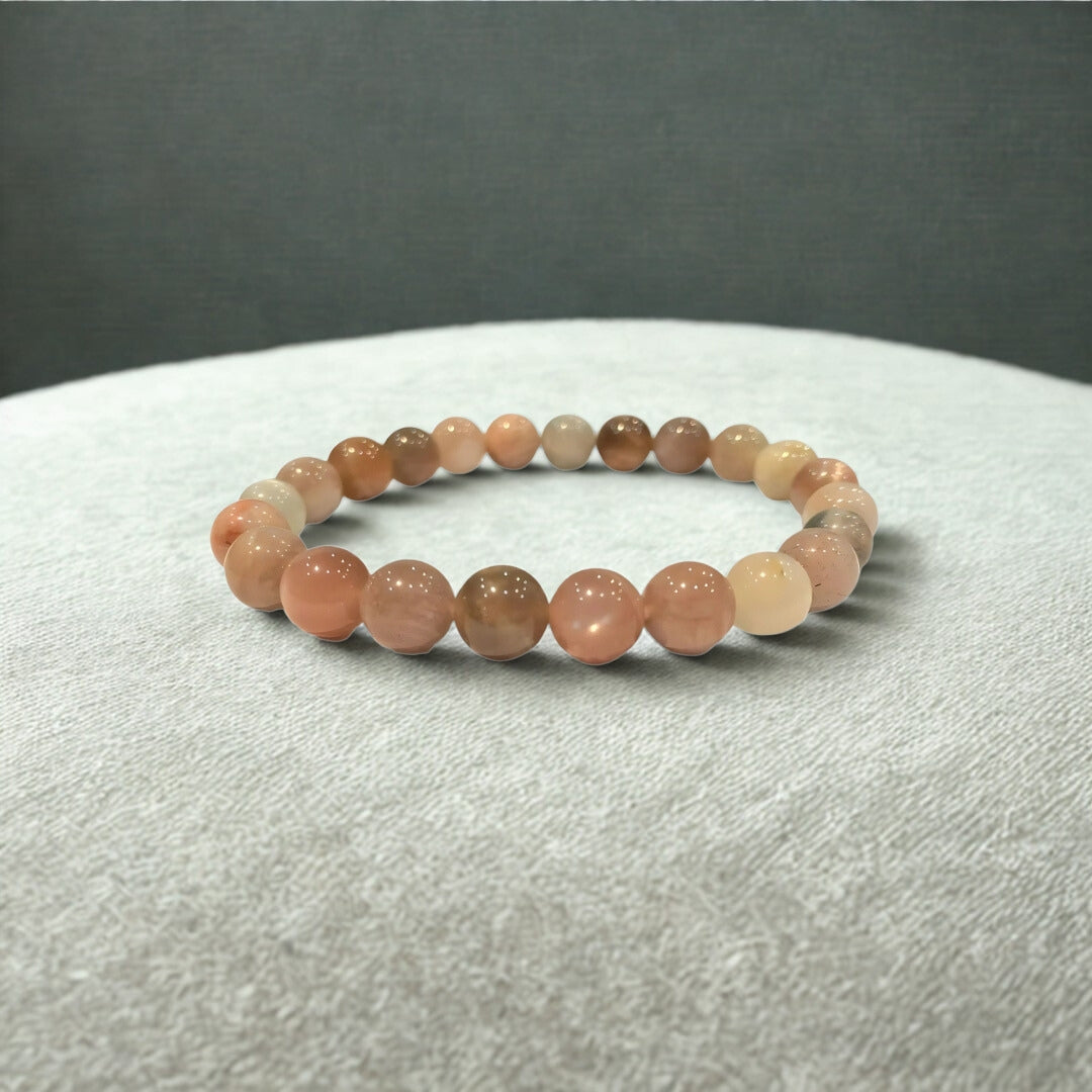 Beaded bracelet with pink and brown stones on a gray background