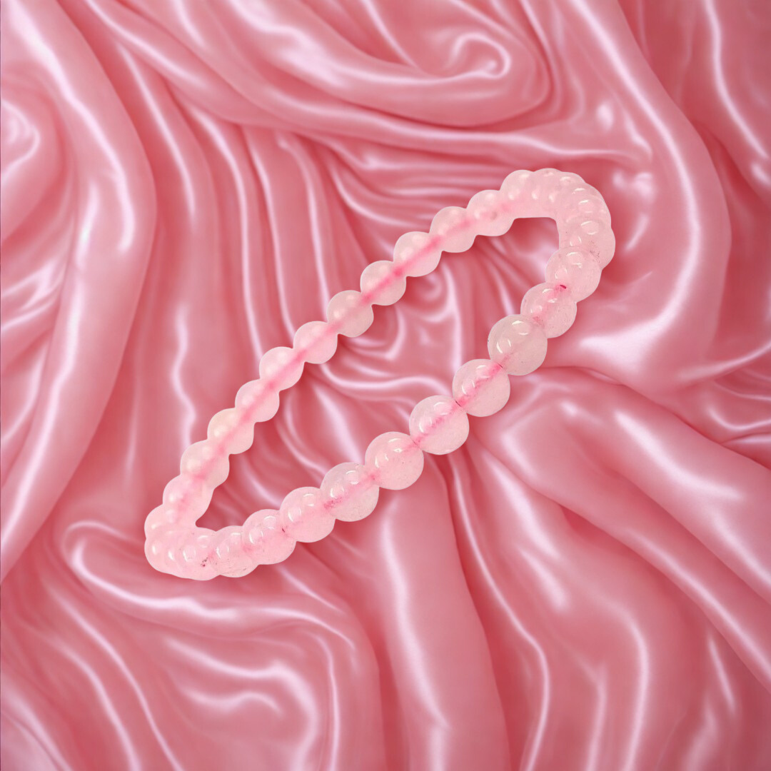 Pink beaded necklace on a pink satin background