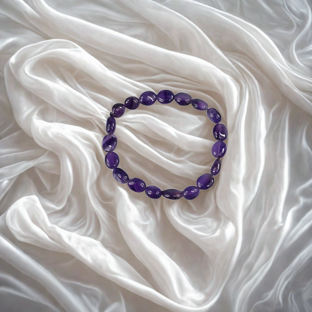 Purple beaded bracelet on white fabric