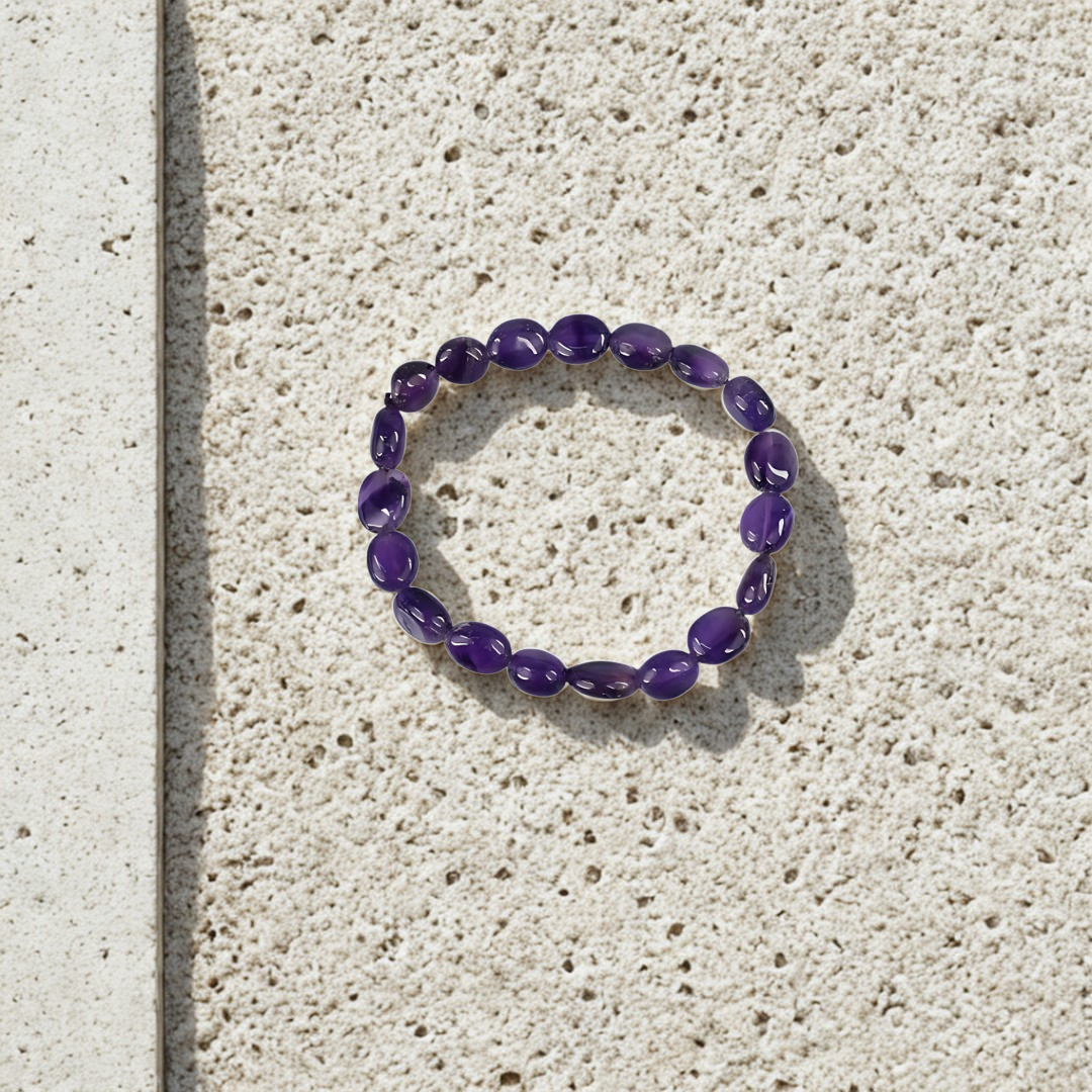 Purple beaded bracelet on a textured stone surface