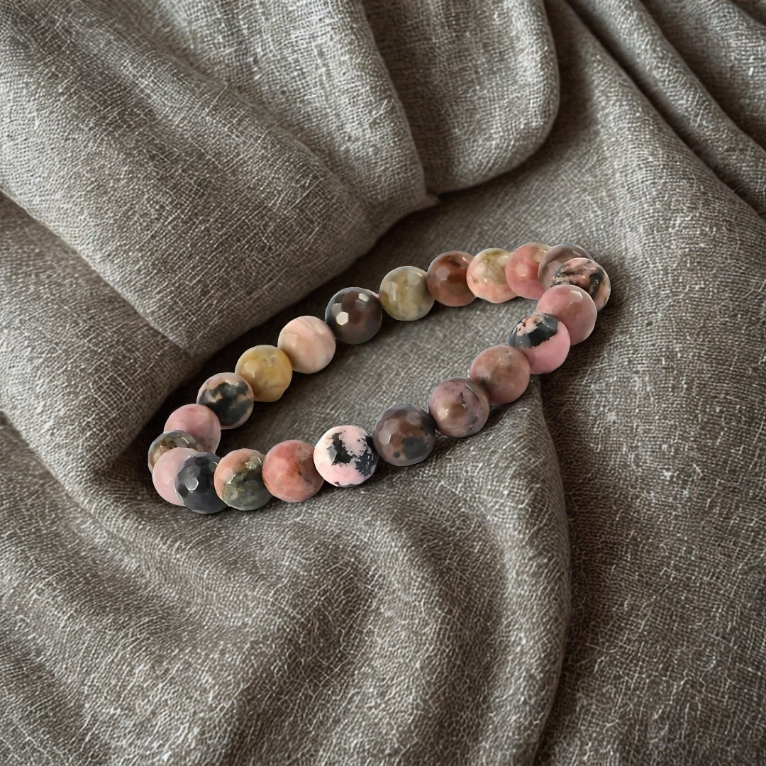 Multicolored beaded bracelet on a textured gray fabric background