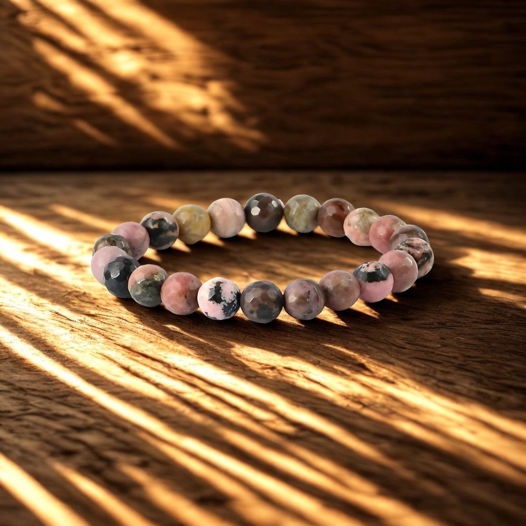 Multicolored beaded bracelet on a wooden surface with sunlight casting shadows