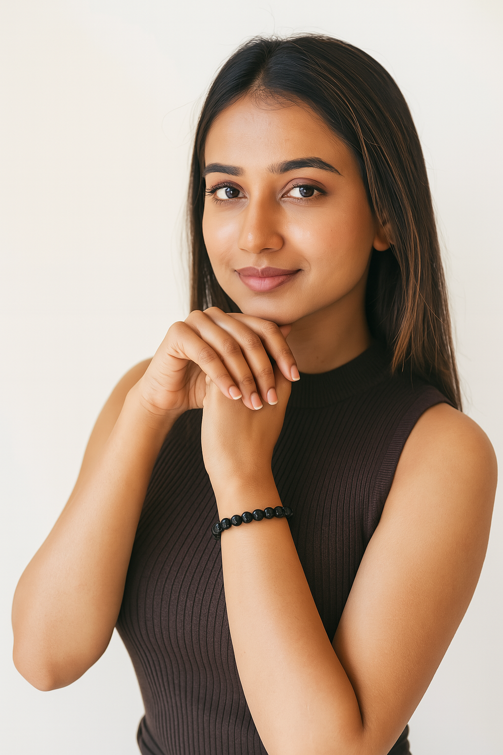 Woman wearing a black sleeveless top with a plain background