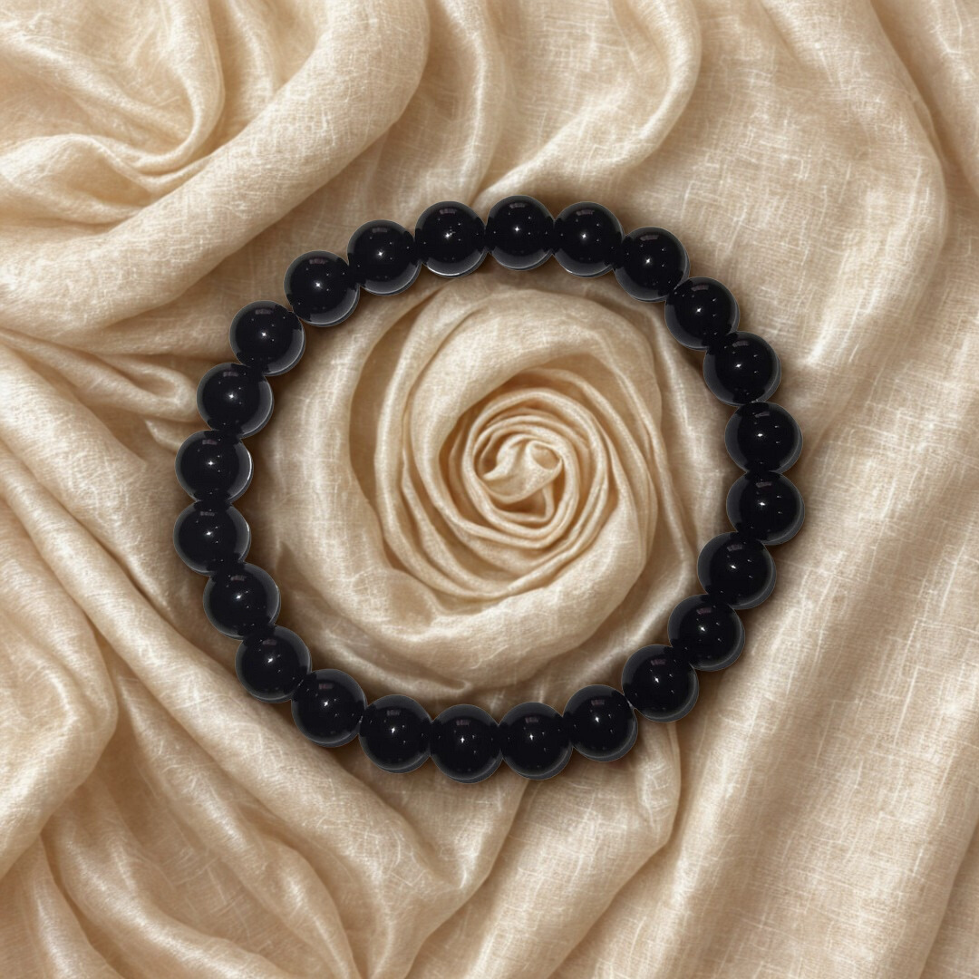 Black beaded bracelet on a beige rose-shaped fabric