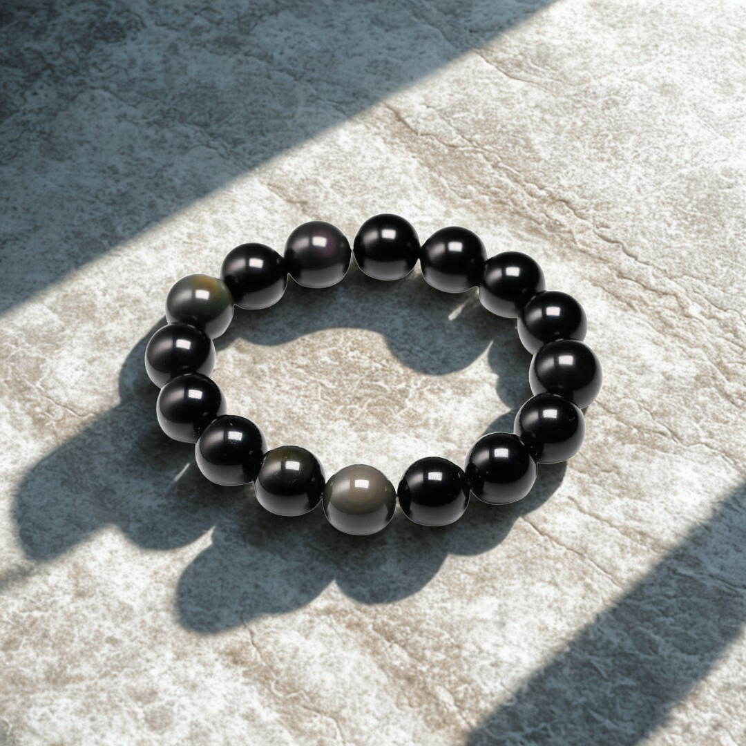 Black beaded bracelet on a textured stone surface