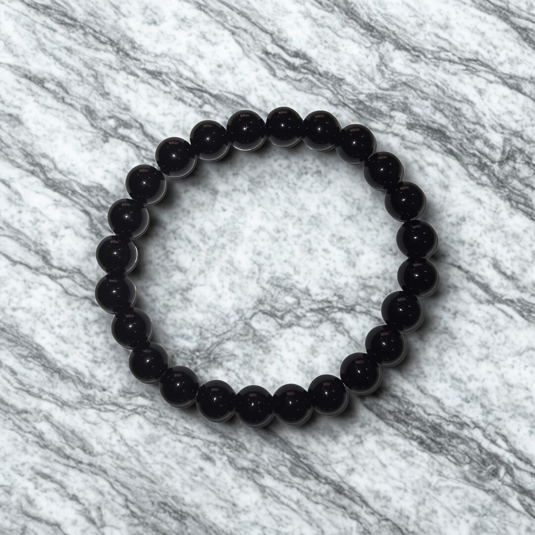 Black beaded bracelet on a marble surface