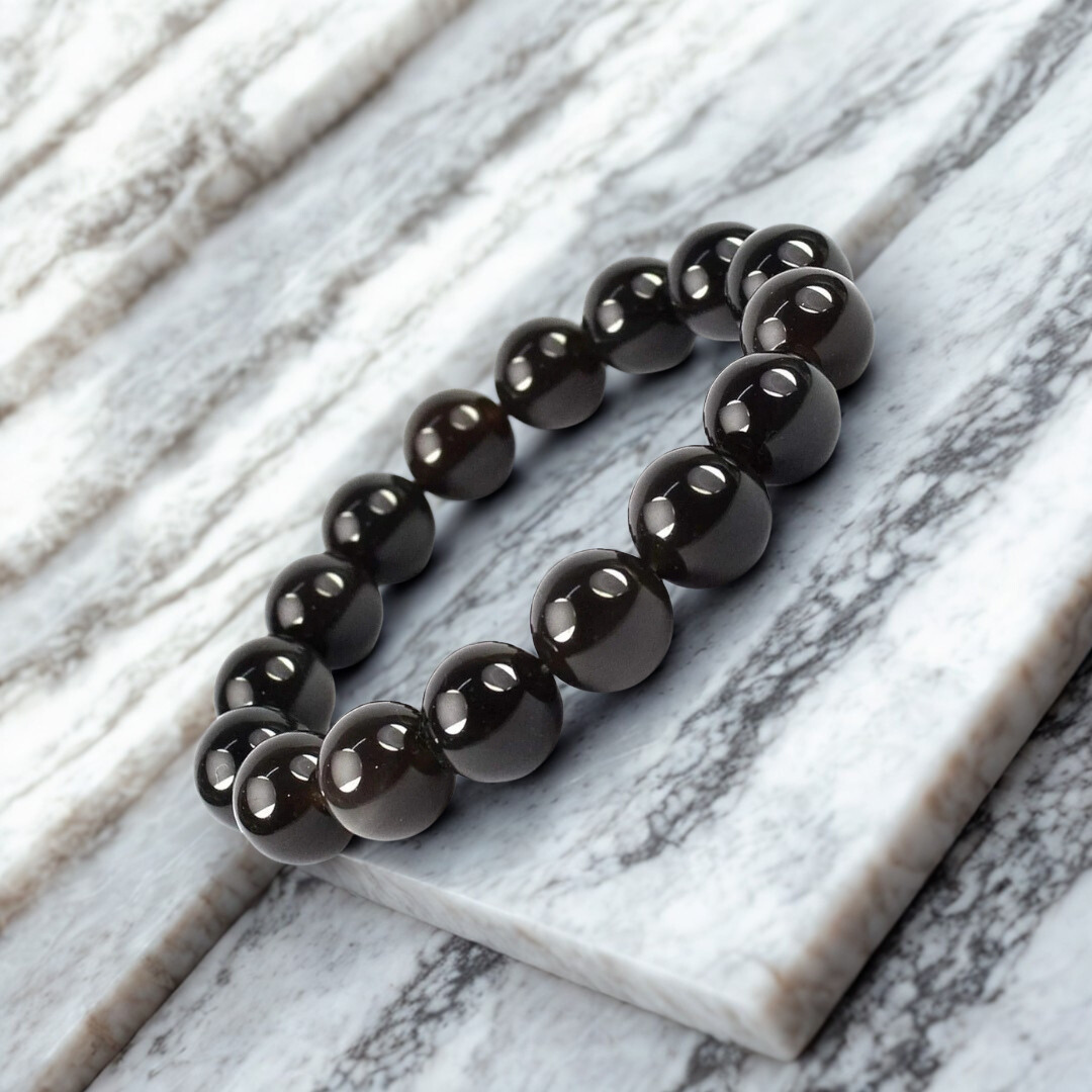 Black beaded bracelet on a marble surface