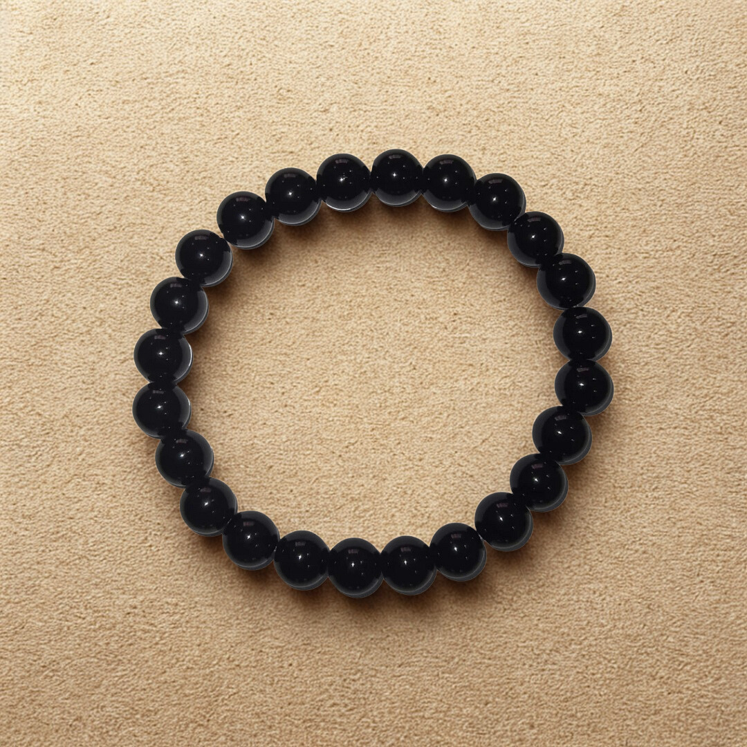 Black beaded bracelet on a beige background