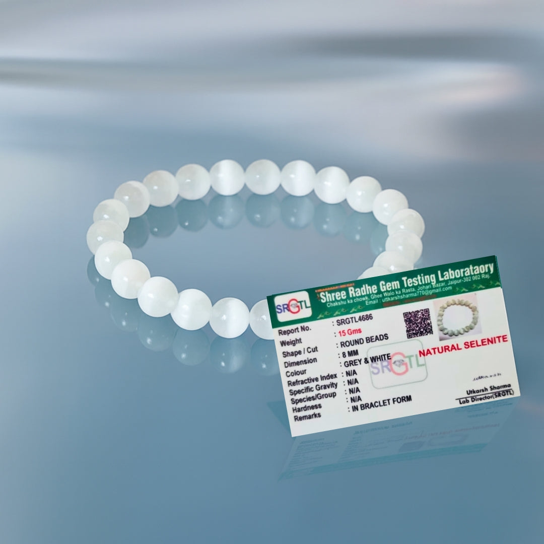White beaded bracelet with a label on a reflective surface