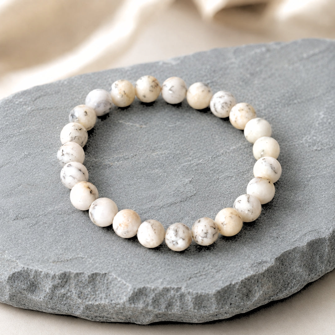 Natural white Opal bracelet displayed on a textured grey stone slab
