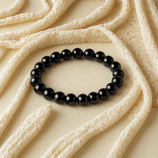 Natural Black Tourmaline Gemstone Bracelet on a textured beige fabric background