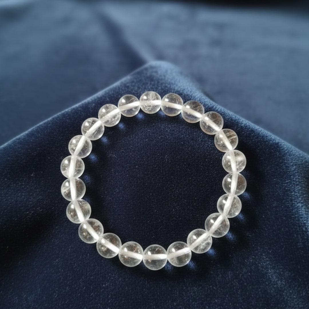 Clear beaded bracelet on a dark blue fabric background