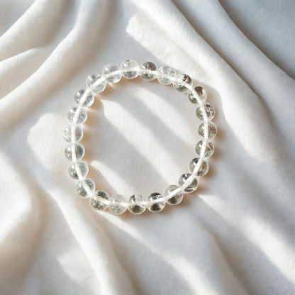 Clear beaded bracelet on a soft white fabric background