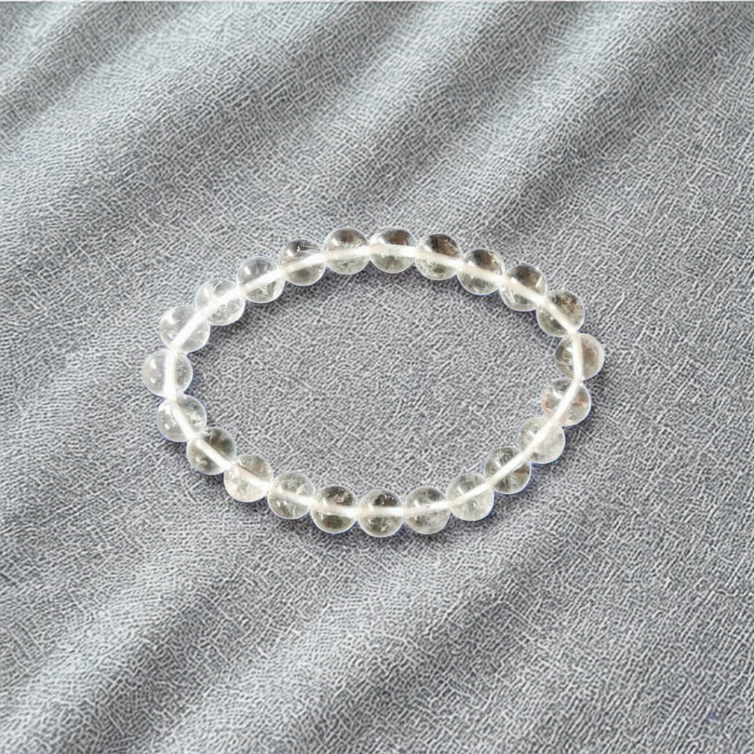 Clear beaded bracelet on a gray fabric background
