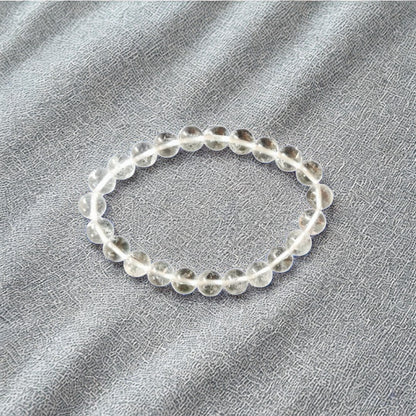 Clear beaded bracelet on a gray fabric background