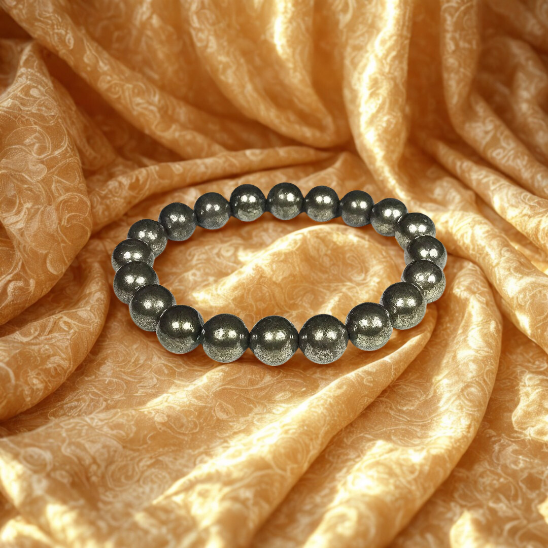 Black beaded bracelet on a textured orange fabric background