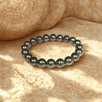 Black beaded bracelet on a textured beige surface