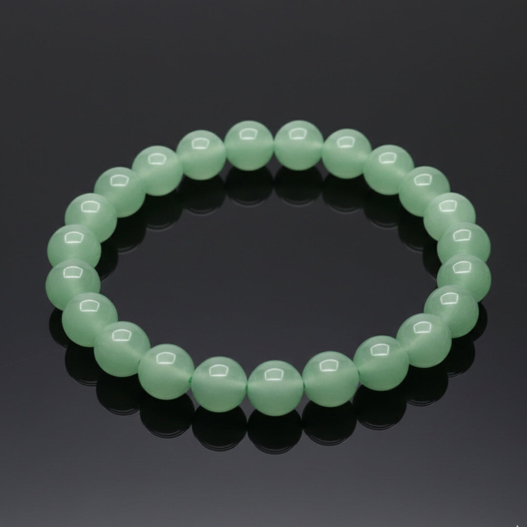 Green beaded bracelet on a reflective black surface