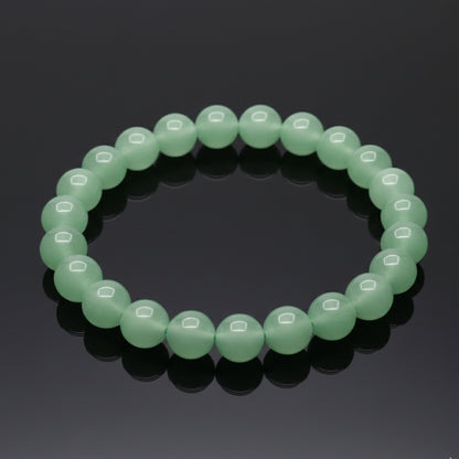 Green beaded bracelet on a reflective black surface