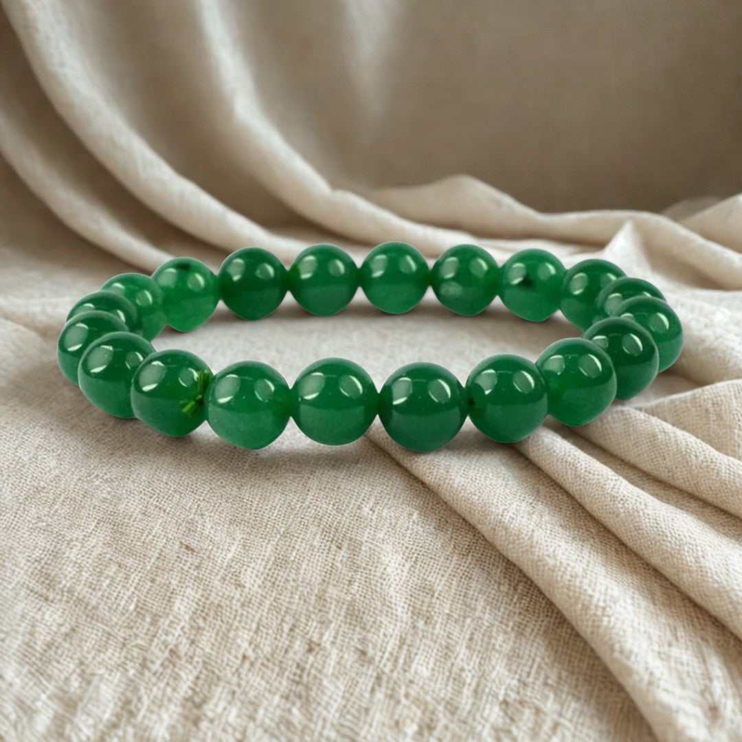 Green beaded bracelet on beige fabric