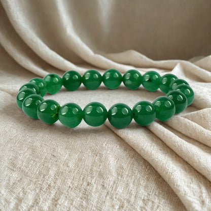 Green beaded bracelet on beige fabric