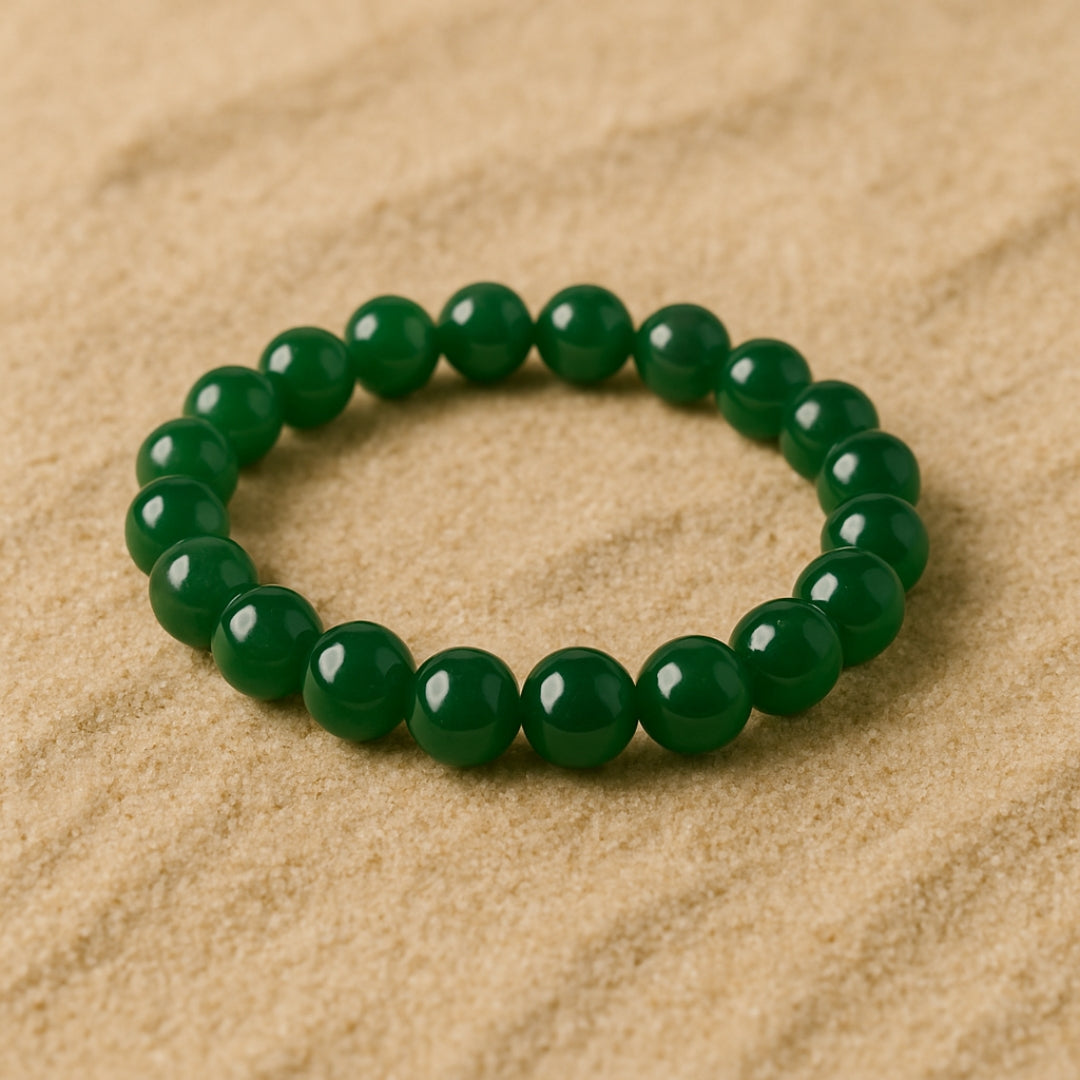 Green beaded bracelet on a sandy background