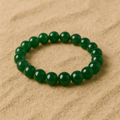 Green beaded bracelet on a sandy background