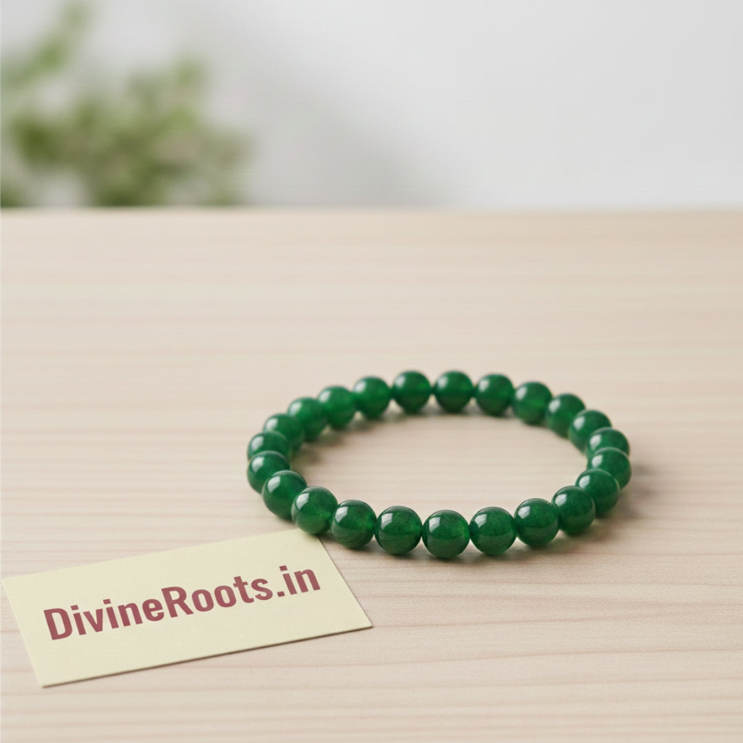 Green beaded bracelet on a wooden surface with a 'DivineRoots.in' card.