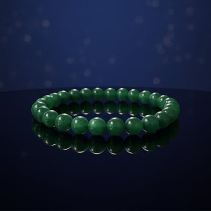 Green beaded bracelet on a reflective surface with a dark blue background