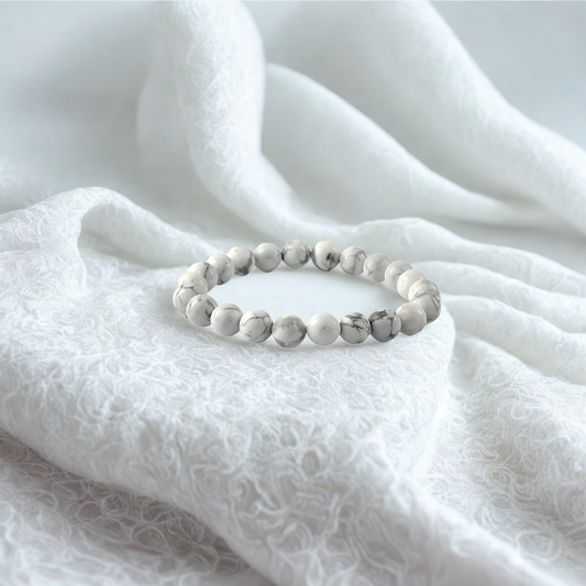 White beaded bracelet on a white fabric background