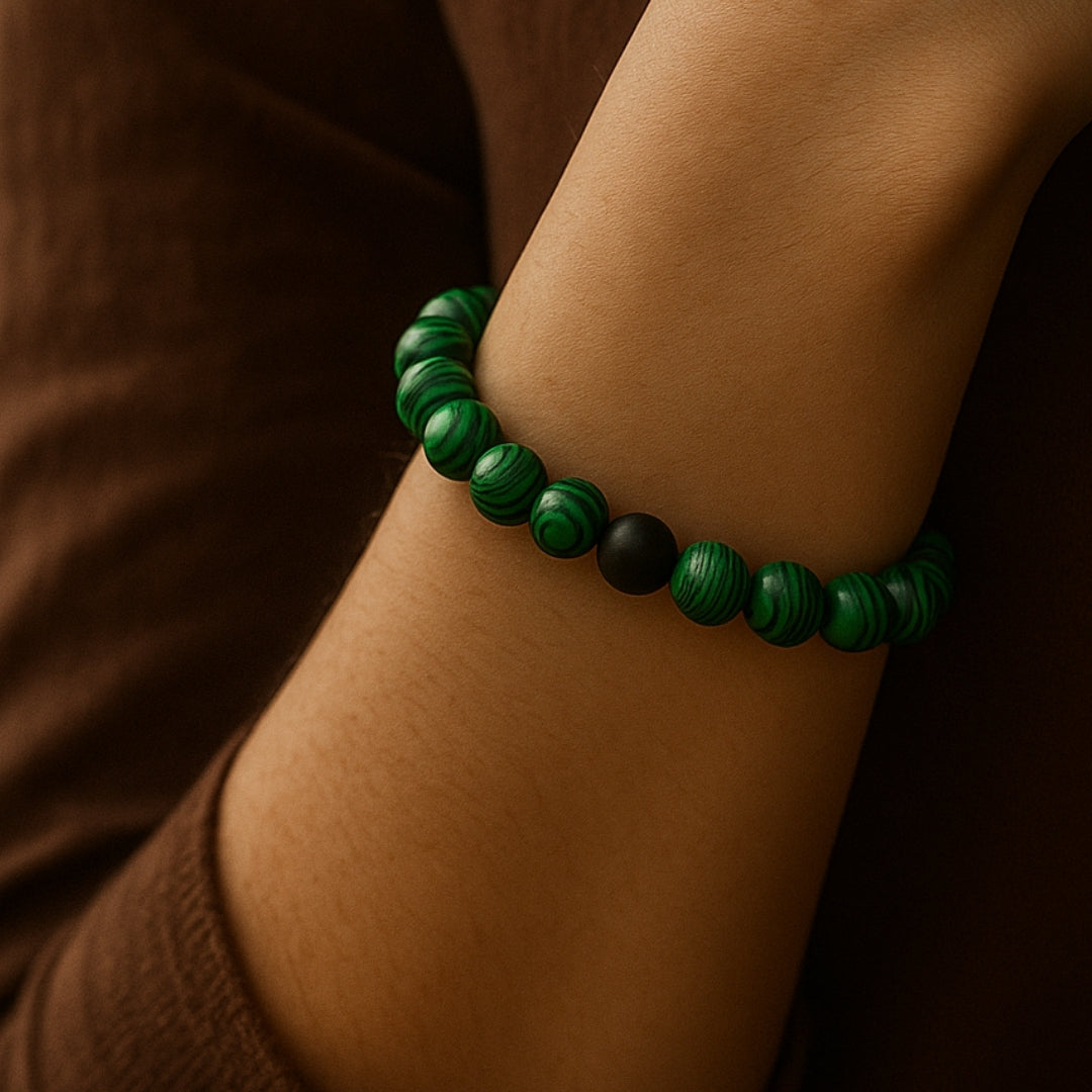 Green beaded bracelet on a wrist with a brown background