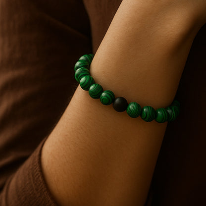 Green beaded bracelet on a wrist with a brown background