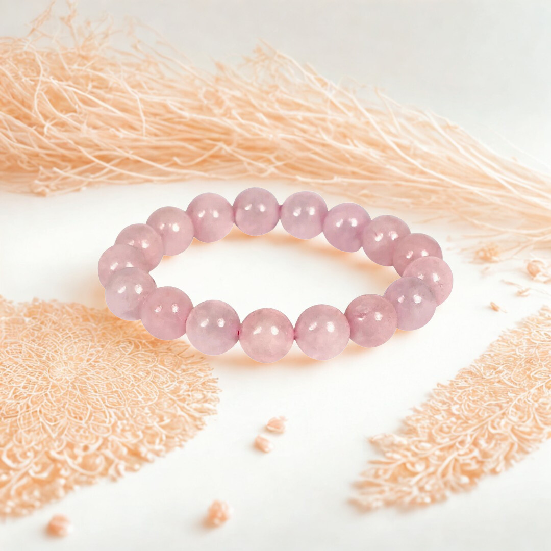 Pink beaded bracelet on a textured white surface