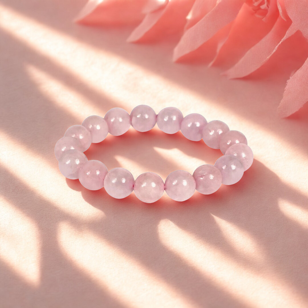 Pink beaded bracelet on a pink surface with floral background