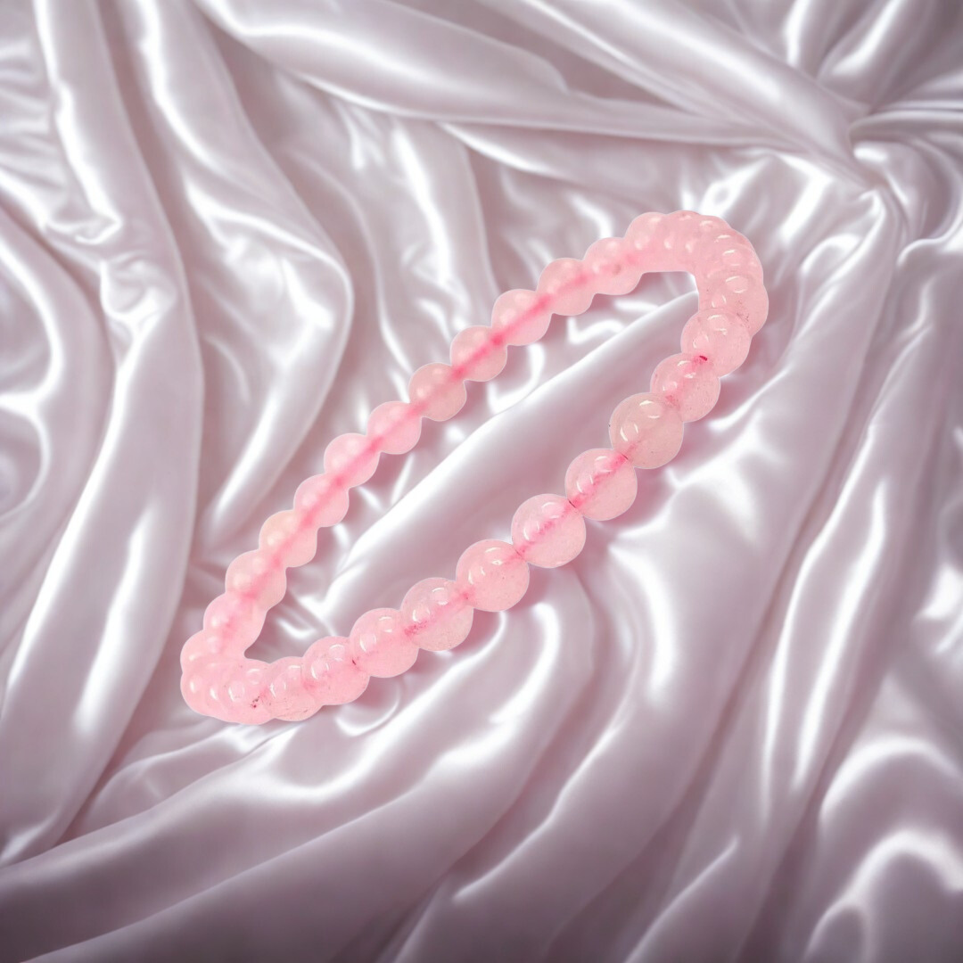 Pink beaded necklace on a textured pink fabric background