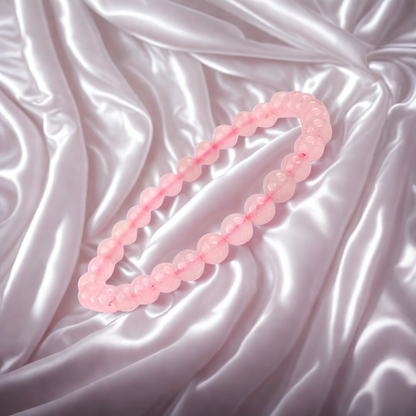 Pink beaded necklace on a textured pink fabric background