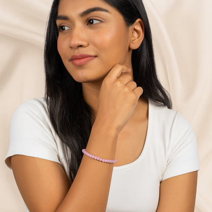Woman wearing a pink bracelet on a beige background