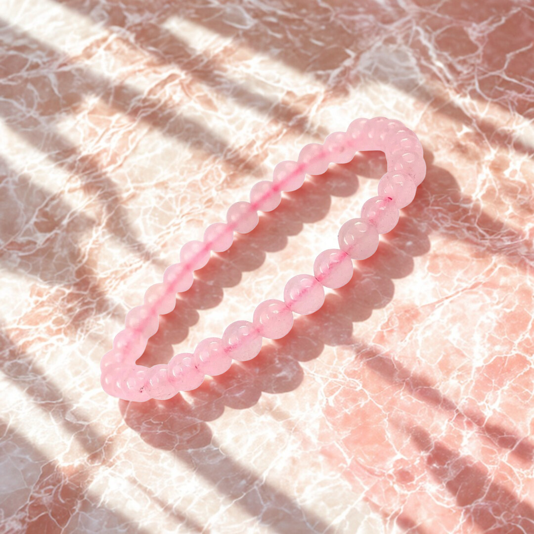 Pink beaded bracelet on a marble surface
