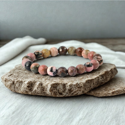Multicolored beaded bracelet on a stone surface with a neutral background