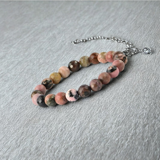 Natural Rhodonite Gemstone Bracelet with multicolored beads on a gray surface