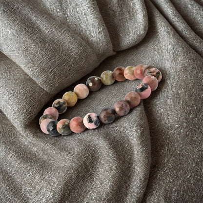 Multicolored beaded bracelet on a textured gray fabric background