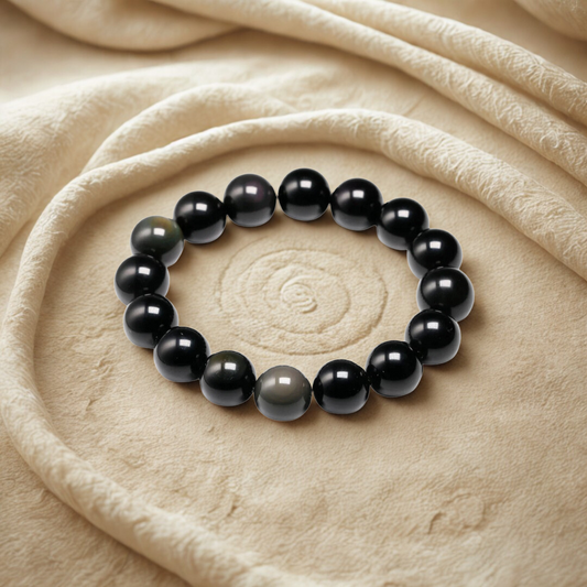 Black beaded bracelet on a beige fabric background
