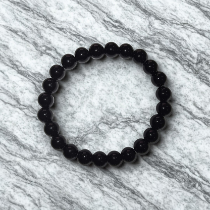 Black beaded bracelet on a marble surface