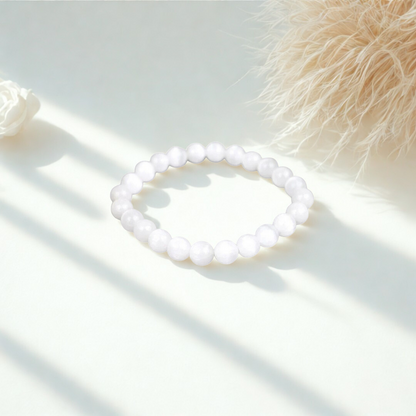 White beaded bracelet on a light surface with soft shadows