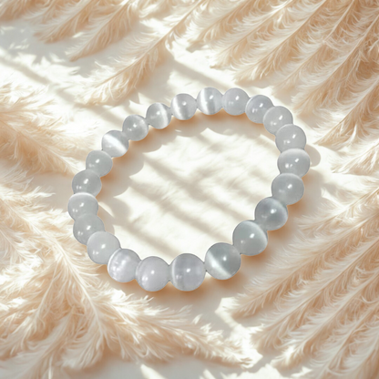 White beaded bracelet on a soft pink feathered surface