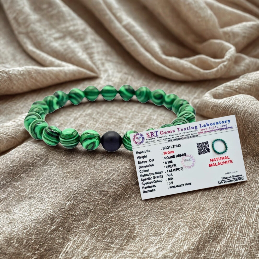 Green beaded bracelet with a label on a beige fabric background