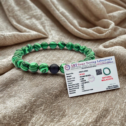 Green beaded bracelet with a label on a beige fabric background