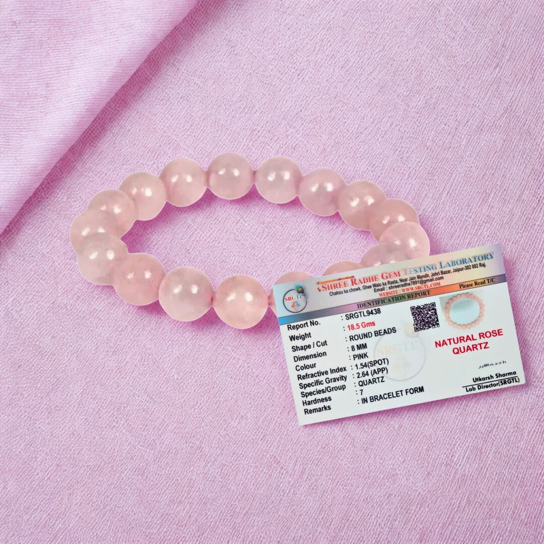 Pink beaded bracelet with a label on a pink background